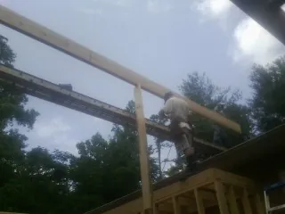 Carpenter setting a ridge beam over a new addition frame — Ice Dam Removal by Roofing Brothers in Mullica Hill